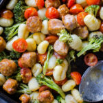 sheet pan gnocchi and sausage dish in pan with spoon