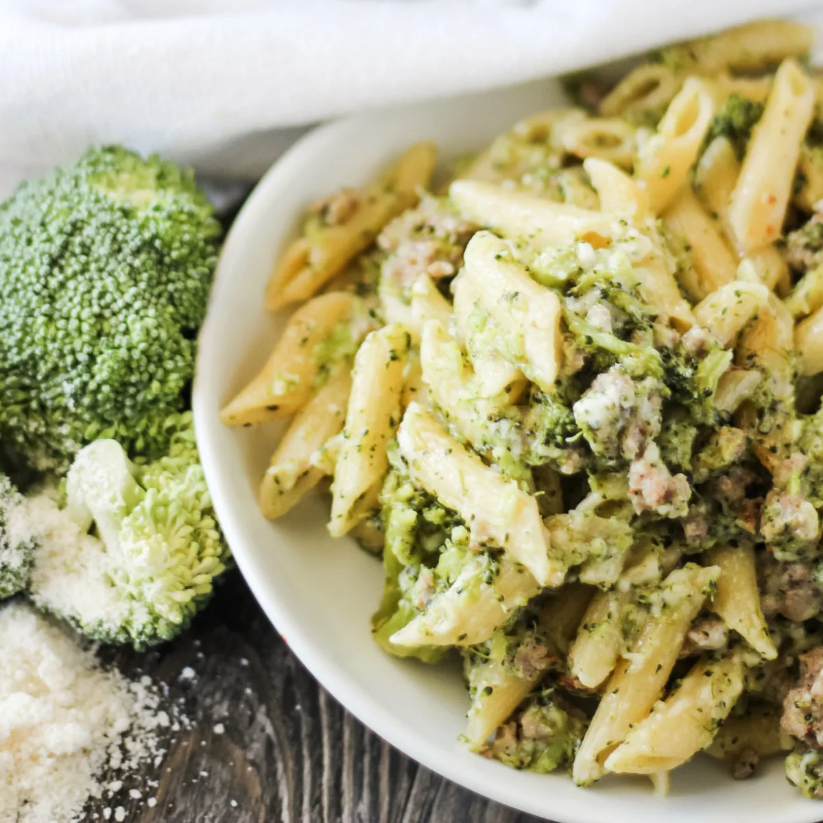 white plate with creamy pasta and broccoli