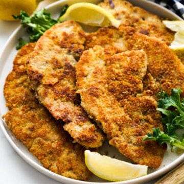 breaded pork chops on plate with lemon