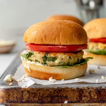 chicken feta burger on tray with tomato