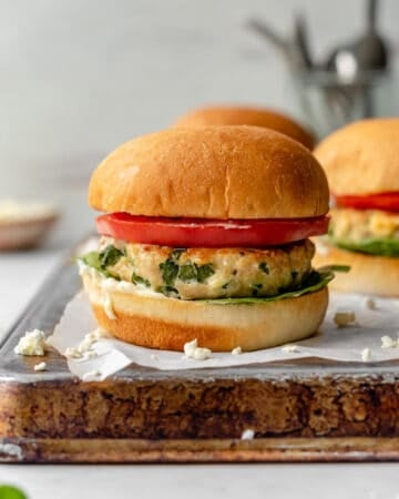 chicken feta burger on tray with tomato