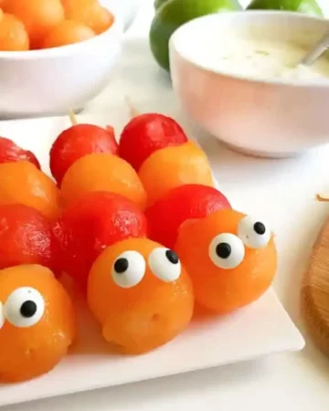 three fruit skewers with candy eyes
