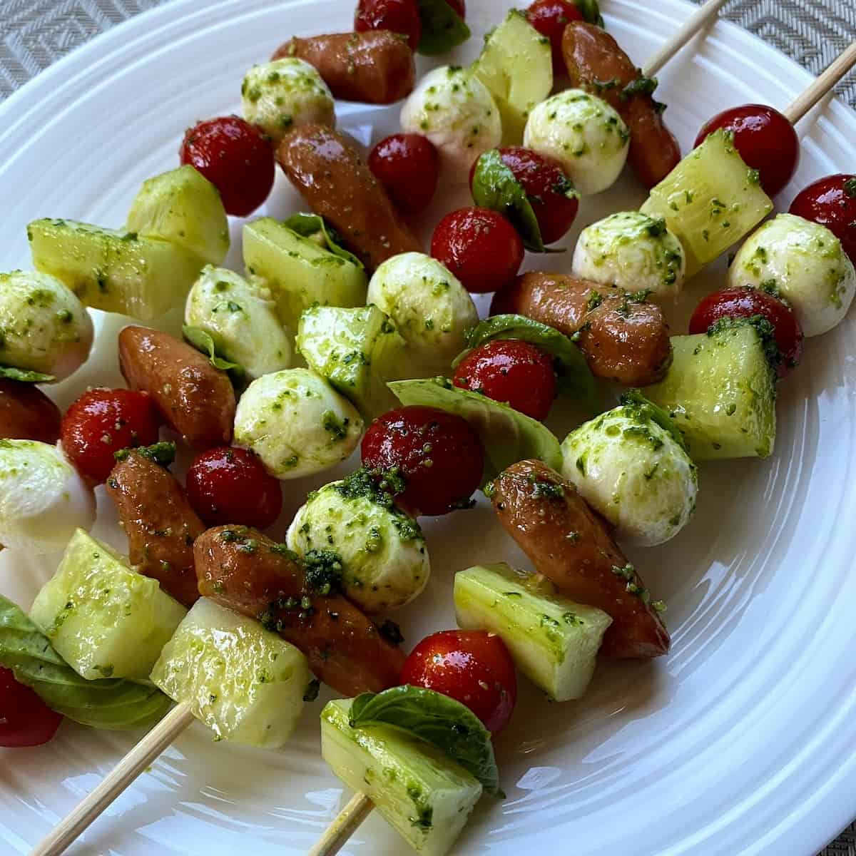 caprese kabobs with spinach and veggies on plate 