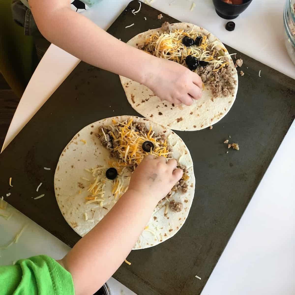 kids making quesadillas on cookie sheet 