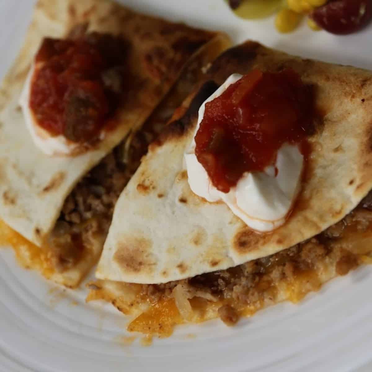 baked quesadilla with sour cream and salsa on top 