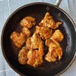 buffalo chicken thighs cooking in pan