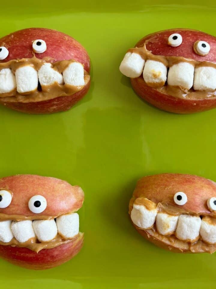 Four apple wedges turned into smiles with marshmallow teeth.