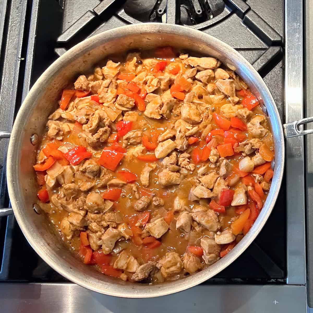 chicken, red pepper and onion cooking in pan