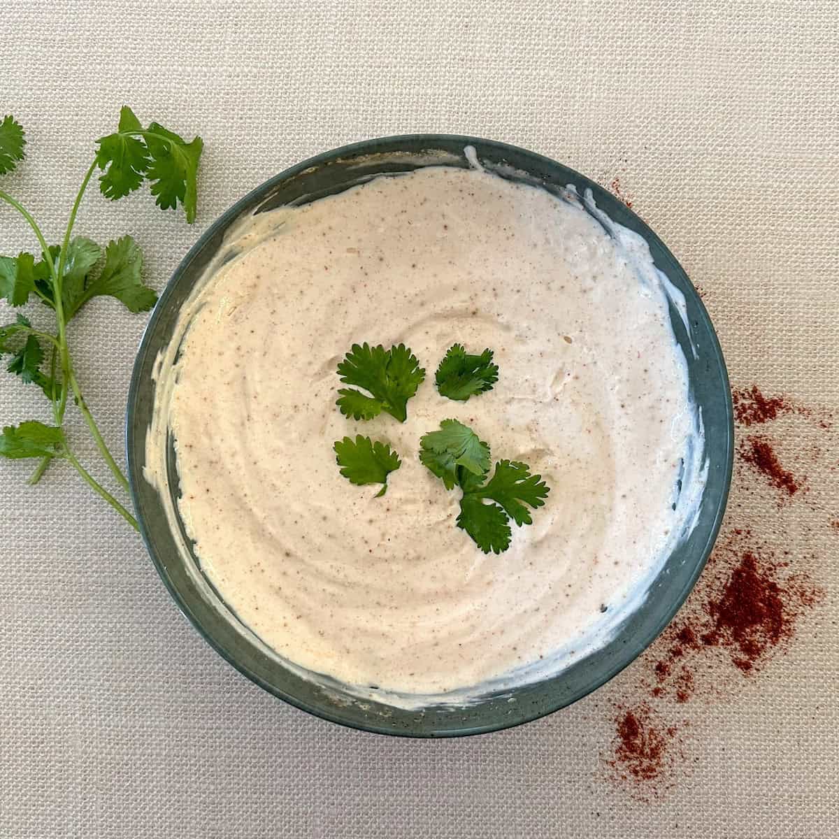 bowl with chipotle crema, cilantro sprigs and red chili powder