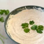 green bowl filled with chipotle crema and cilantro leaves