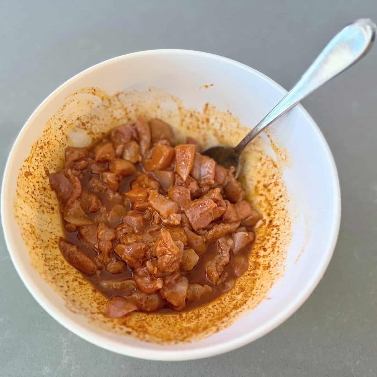 white bowl filled with chicken in marinade