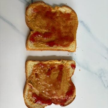 An open faced peanut butter and jelly sandwich. 