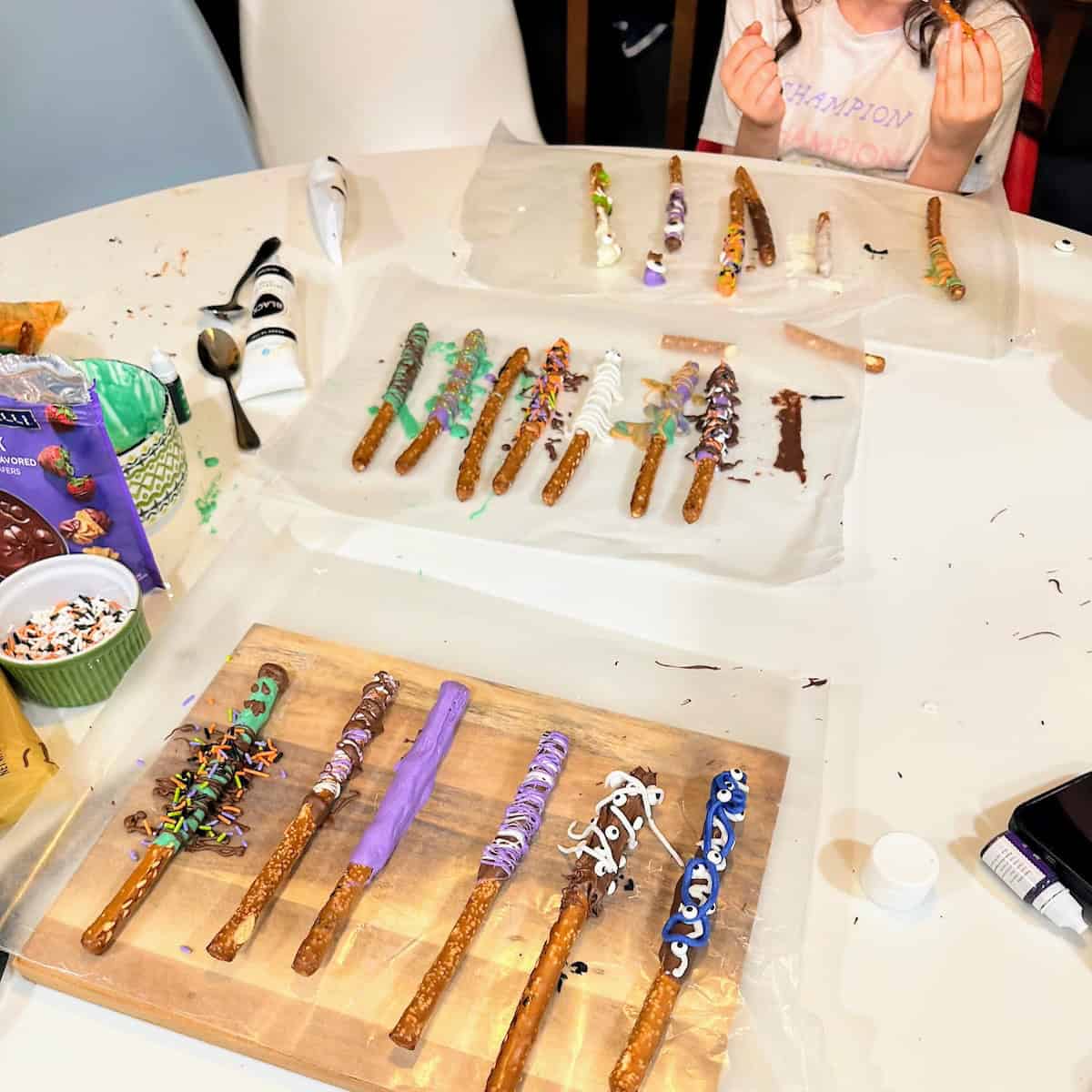 kids making Halloween pretzel monsters at kitchen table