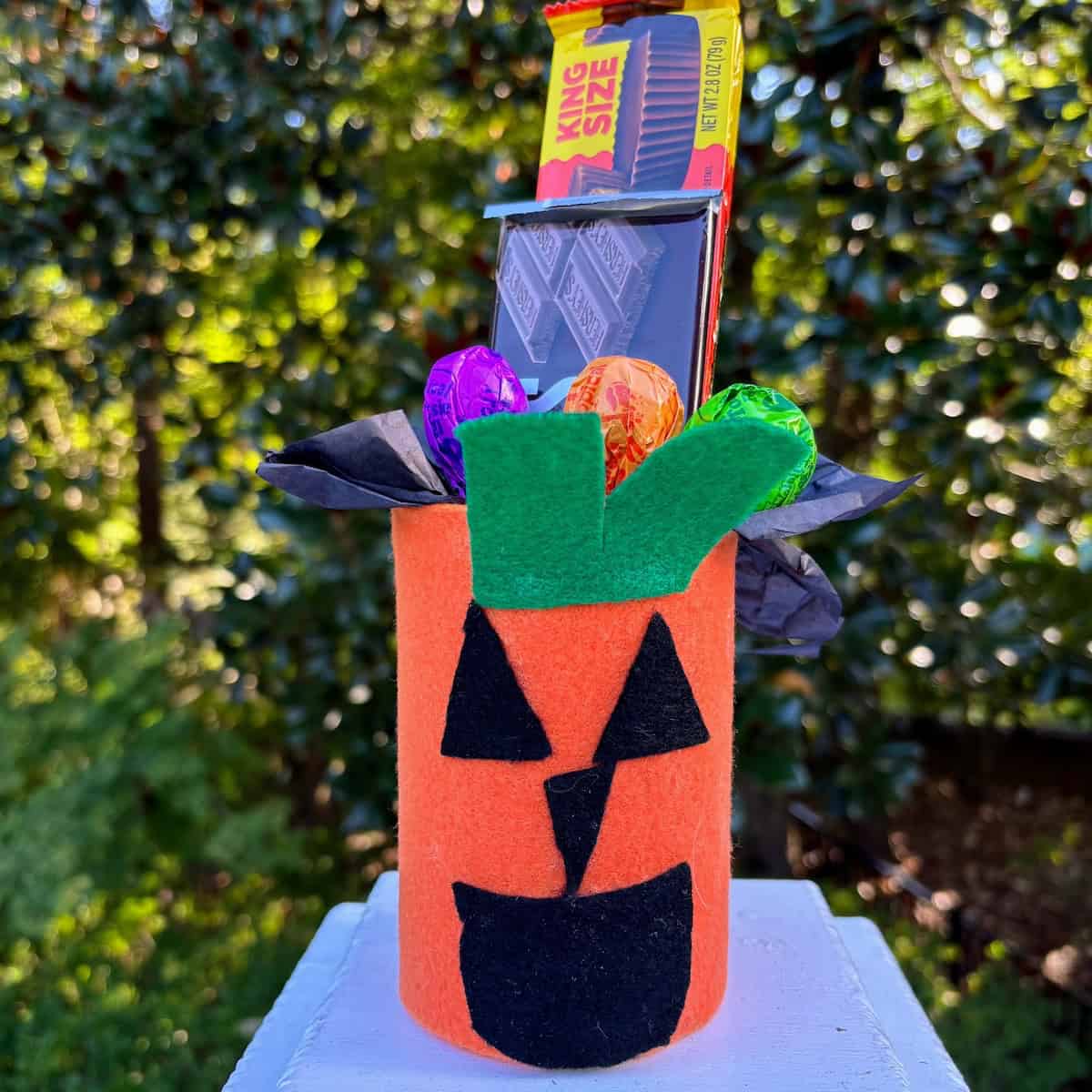 Pumpkin craft made from a can and filled with candy bars and lollipops. 