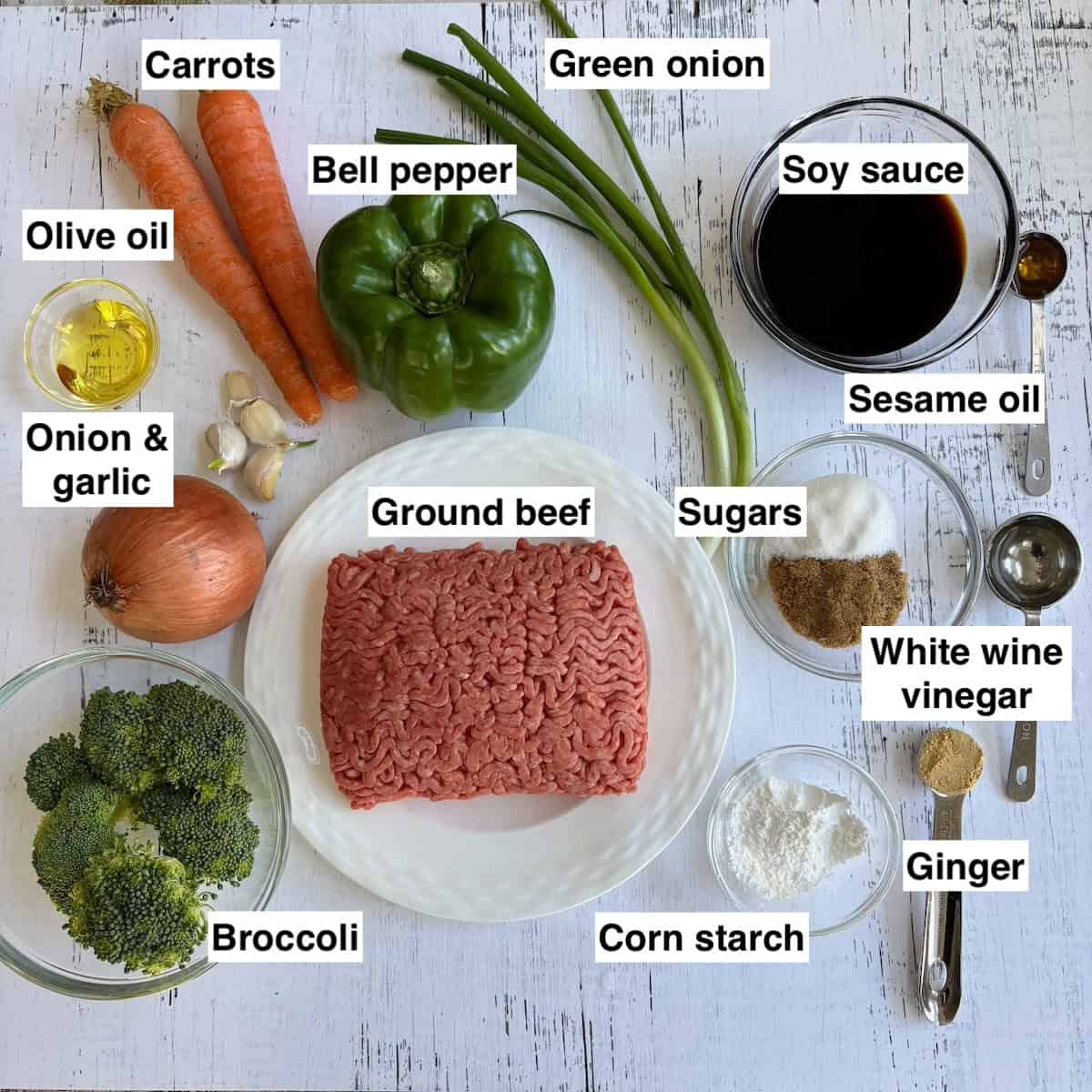 Ingredients for teriyaki rice bowl aid out on white board. 