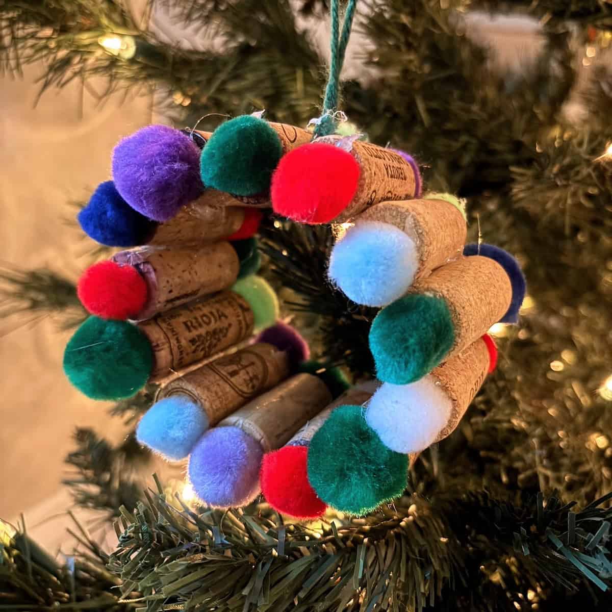 Wreath ornament made from wine corks and colored pom-poms.