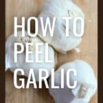 three heads of garlic on a cutting board