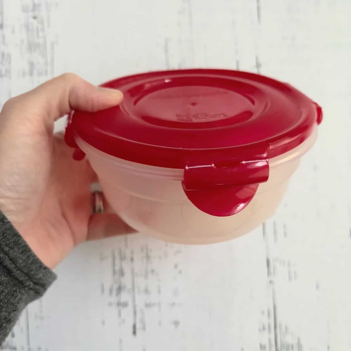 container sealed and being shaken to loosen garlic cloves from their skins. 