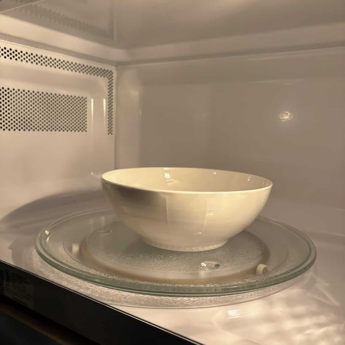 A bowl of garlic cloves in the microwave. 