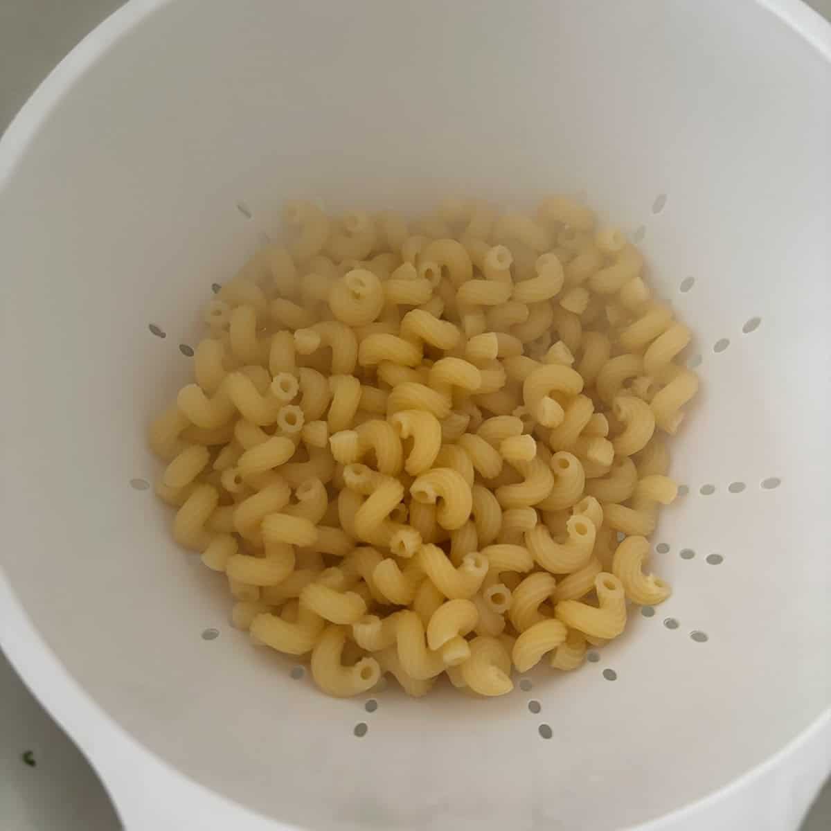 Cavatappi pasta in a strainer after being cooked. 