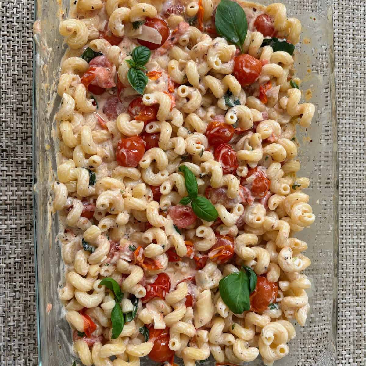 Boursin tomato pasta cooked and mixed together to form a creamy pasta dish and topped with basil. 
