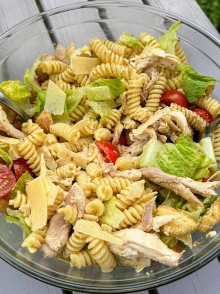 Caesar salad pasta in large bowl on deck table, ready to serve