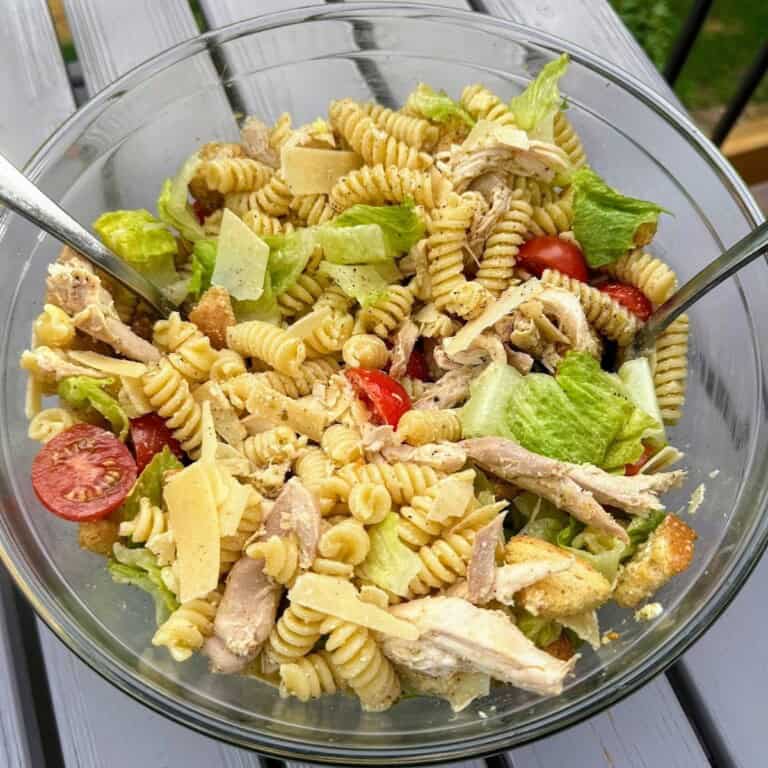 Caesar salad pasta in large bowl on deck table, ready to serve