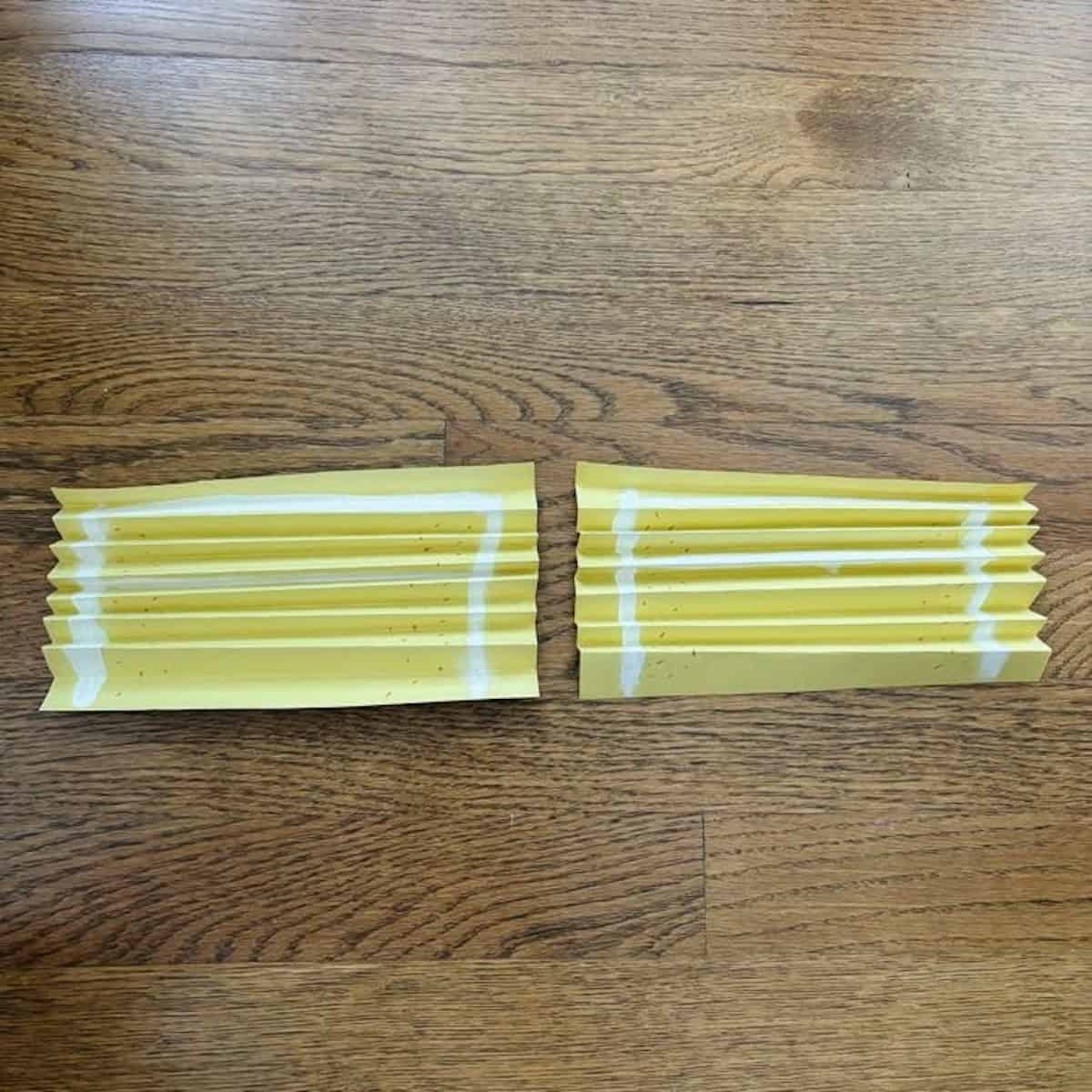 Two accordion folded yellow pieces of paper.