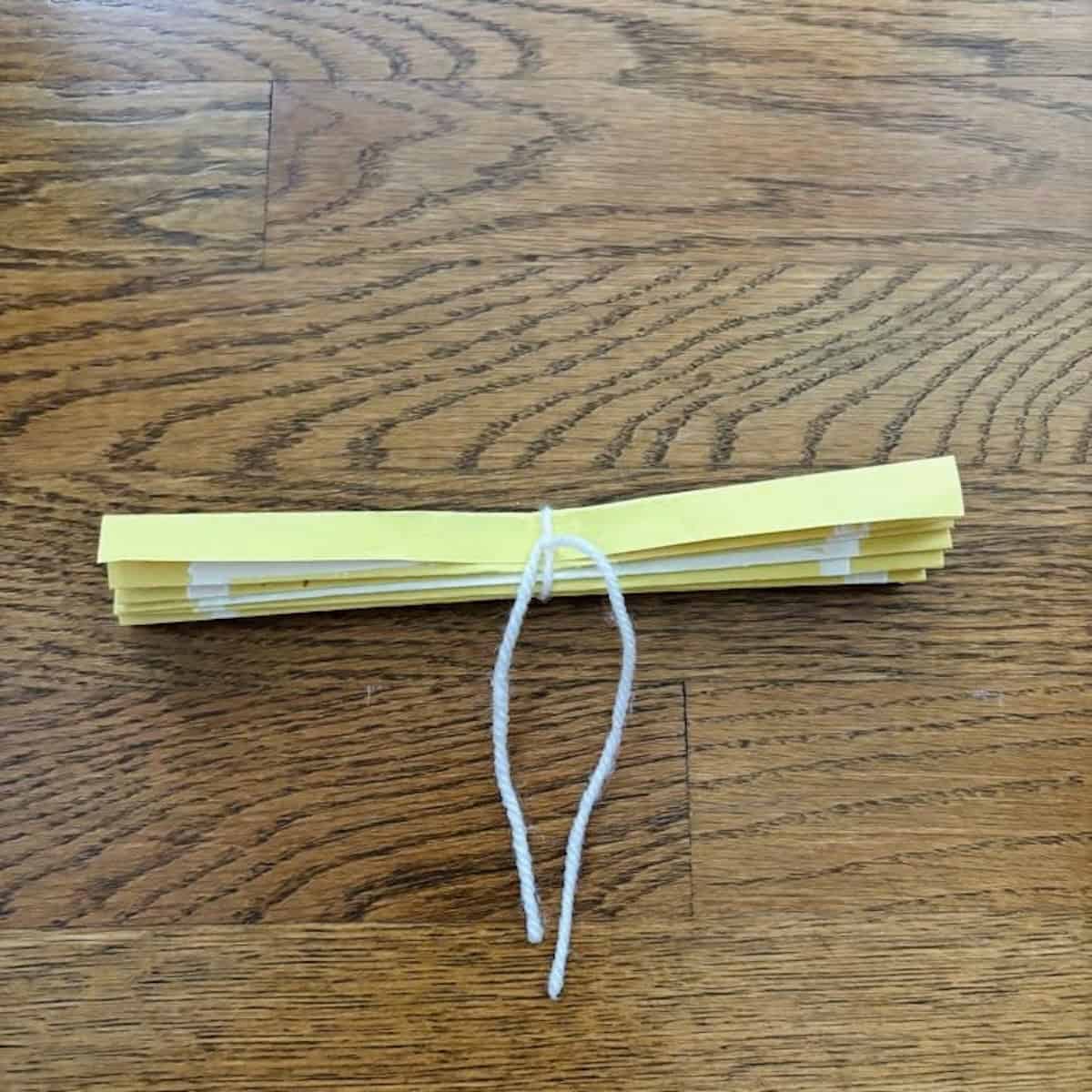 Yellow paper with string tied n the middle to form a fan.