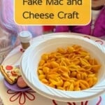 A bowl of colored dry and yellow pasta on a play table with dolls.