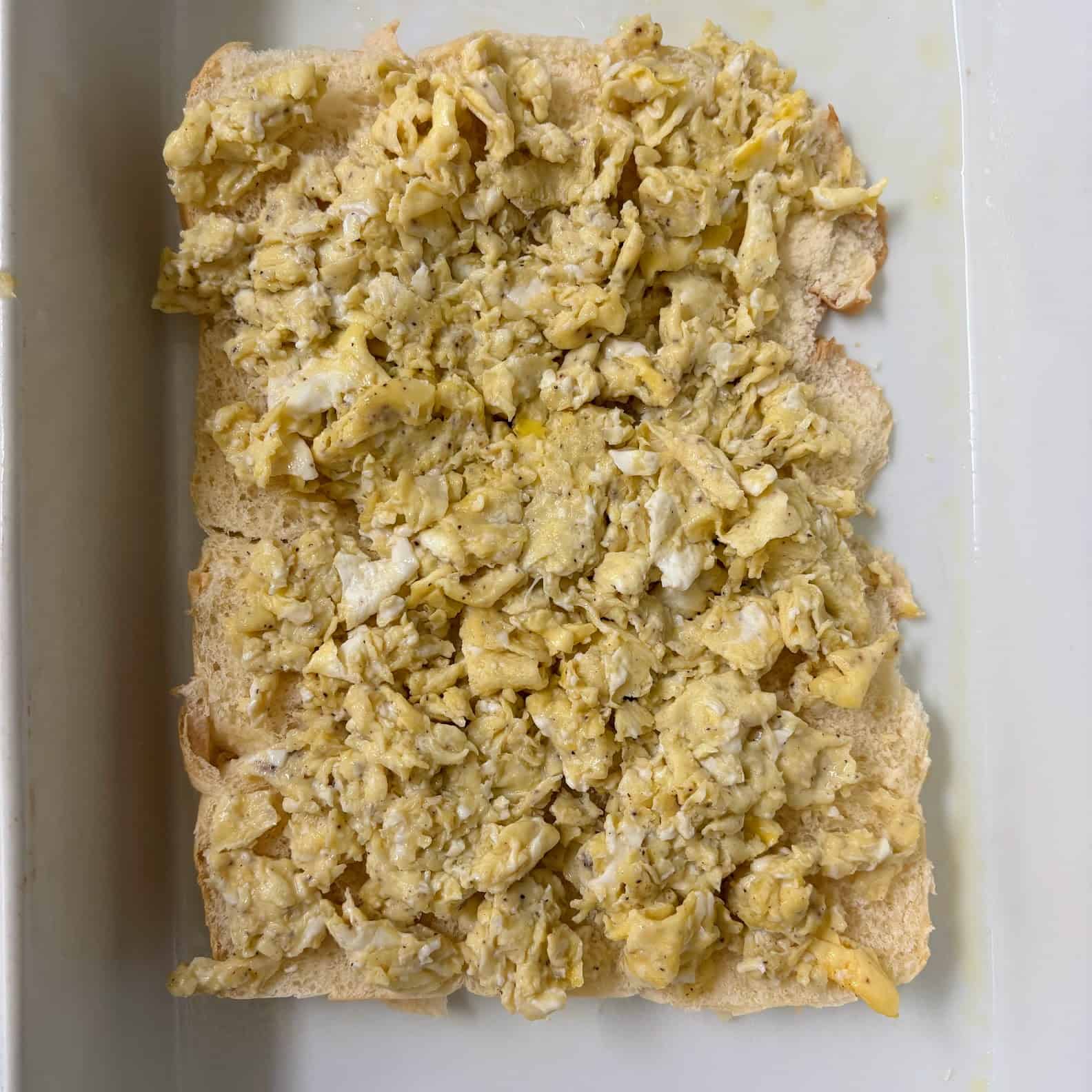 Hawaiian rolls covered with scrambled eggs.