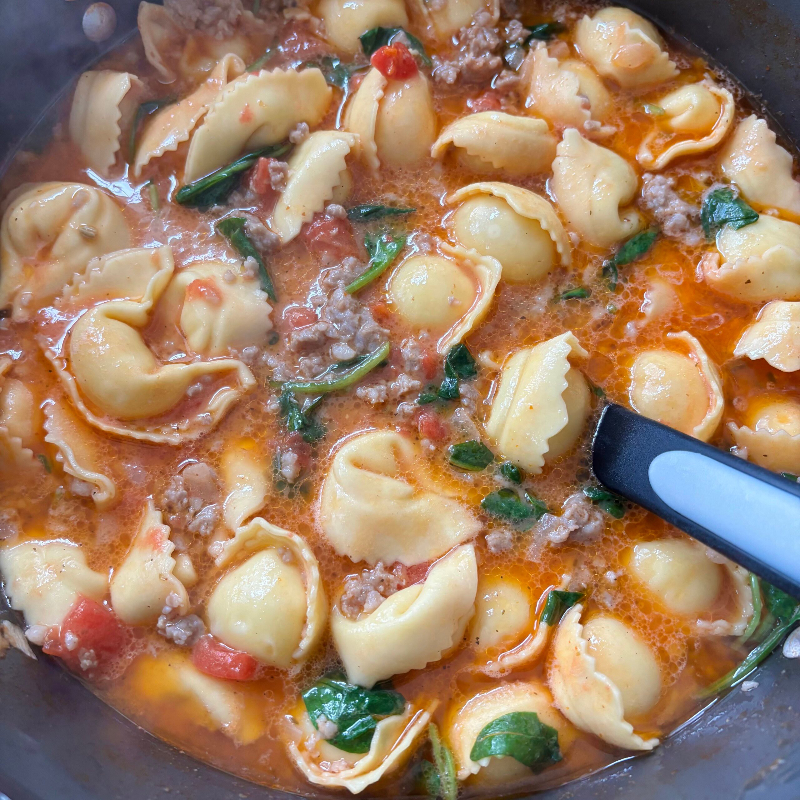 Cheesy tortellini soup with ground beef and spinach in a savory tomato broth. Perfect comforting meal.