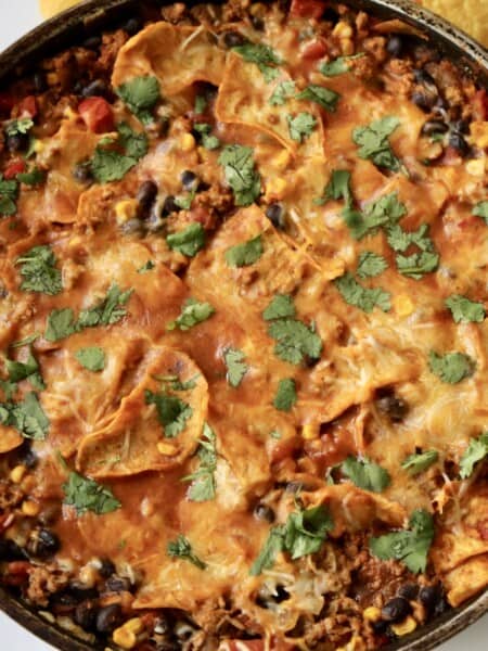 A closeup of an enchilada skillet made with ground turkey, veggies and cheese.