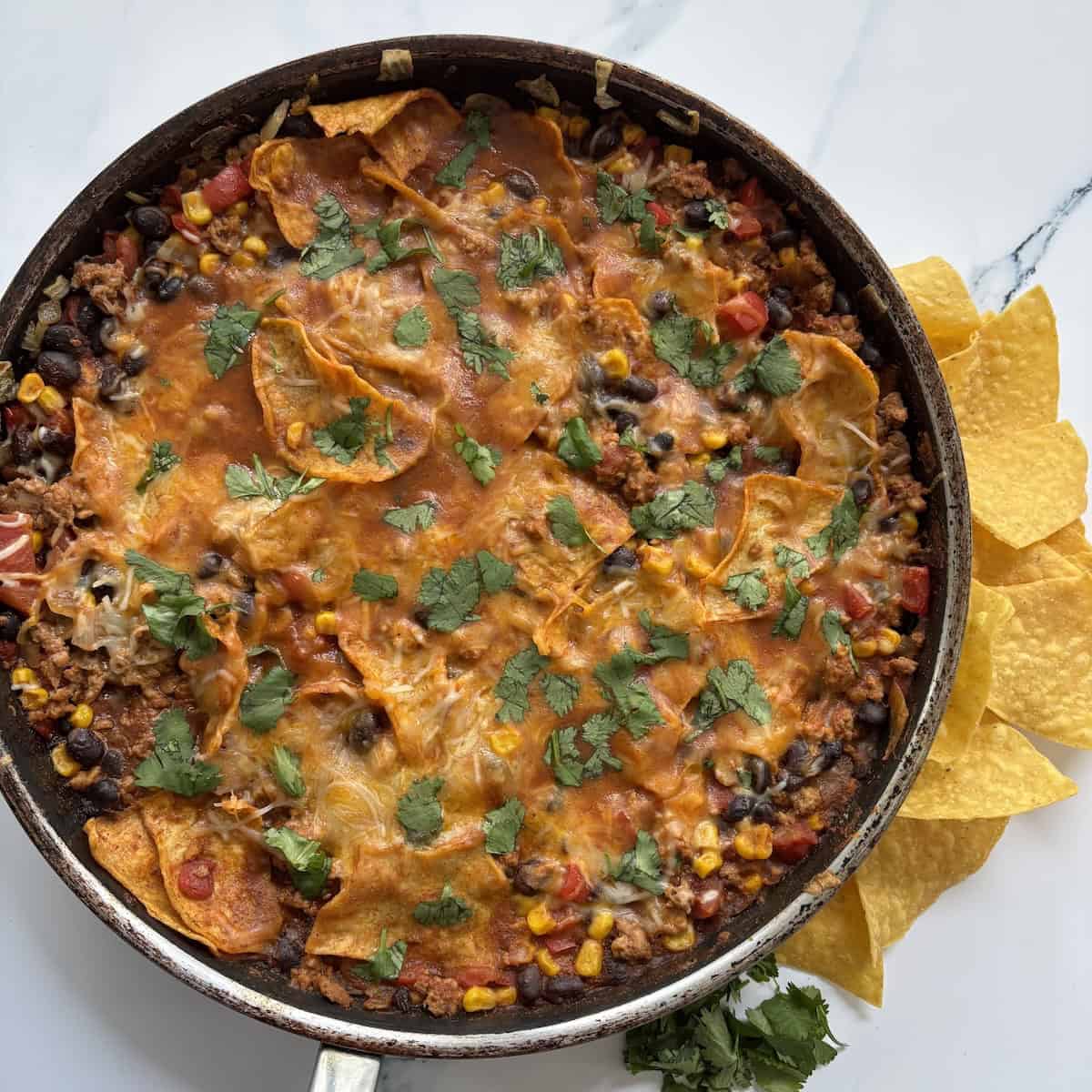 A pan filled with beans, meat and veggies.