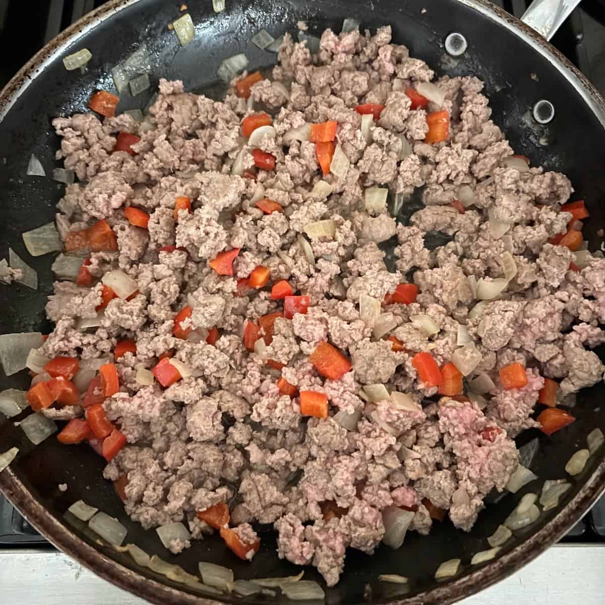 Veggies and ground turkey cooking in pan for enchilada skillet.