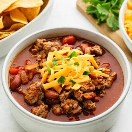 A bowl of gourd turkey chili for picky eaters with cheese on top.