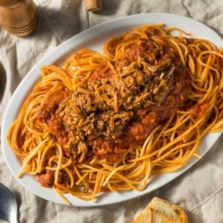 BBQ spaghetti are with ground meat designed for kids and families on a white plate.