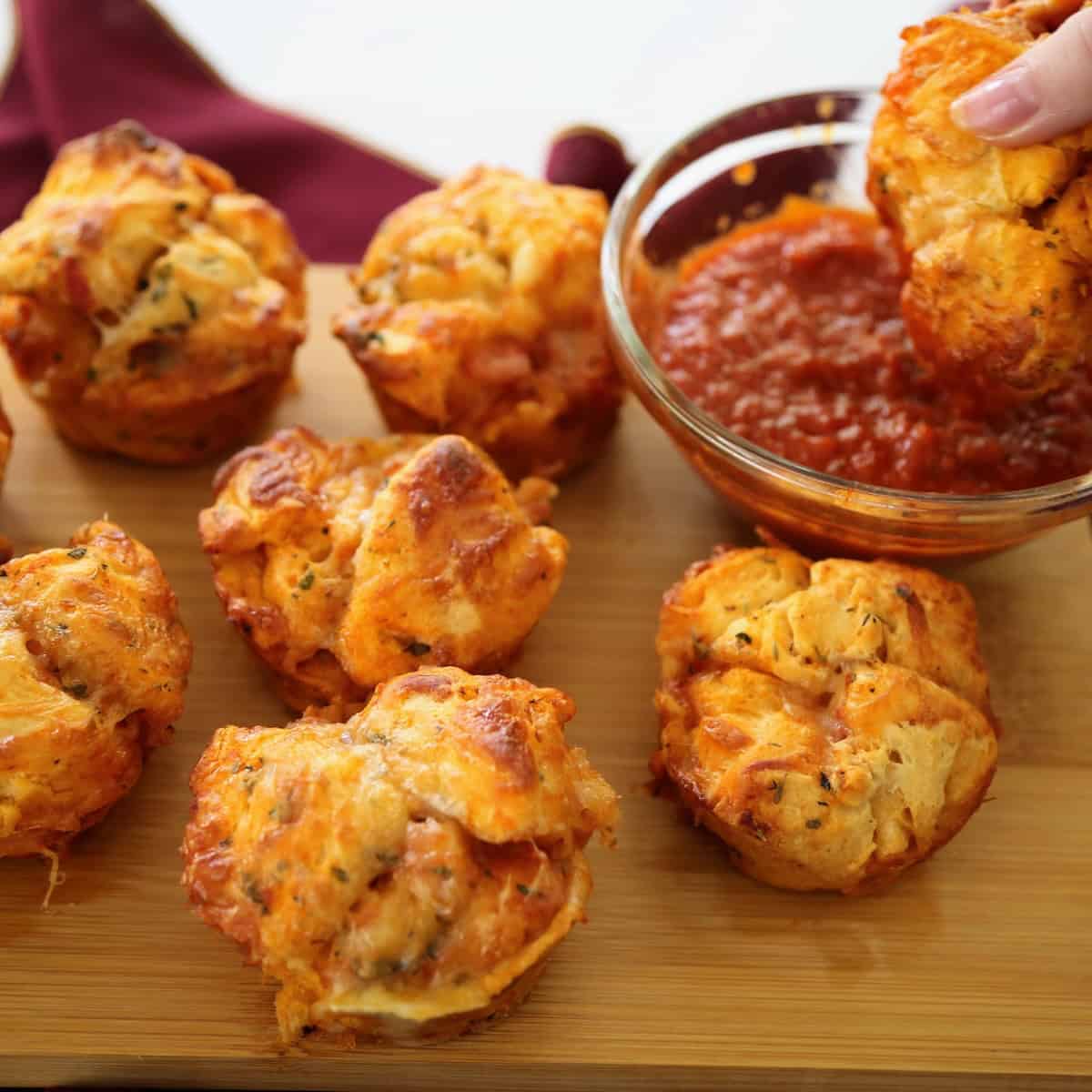 dipping a pizza muffin into marinara sauce
