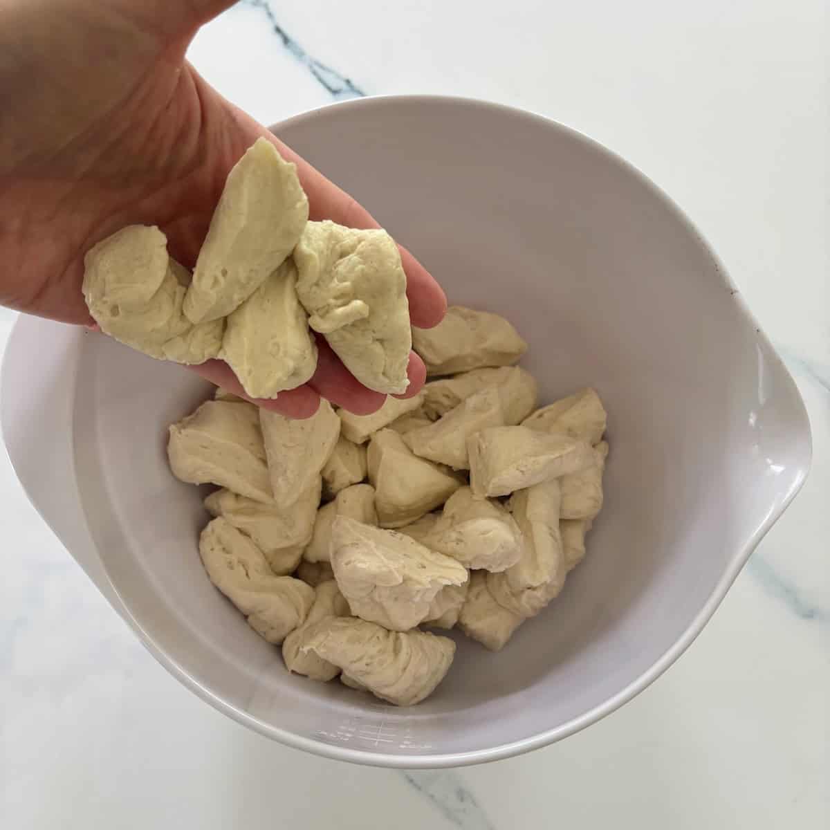Biscuits broken into small pieces for pizza muffins.